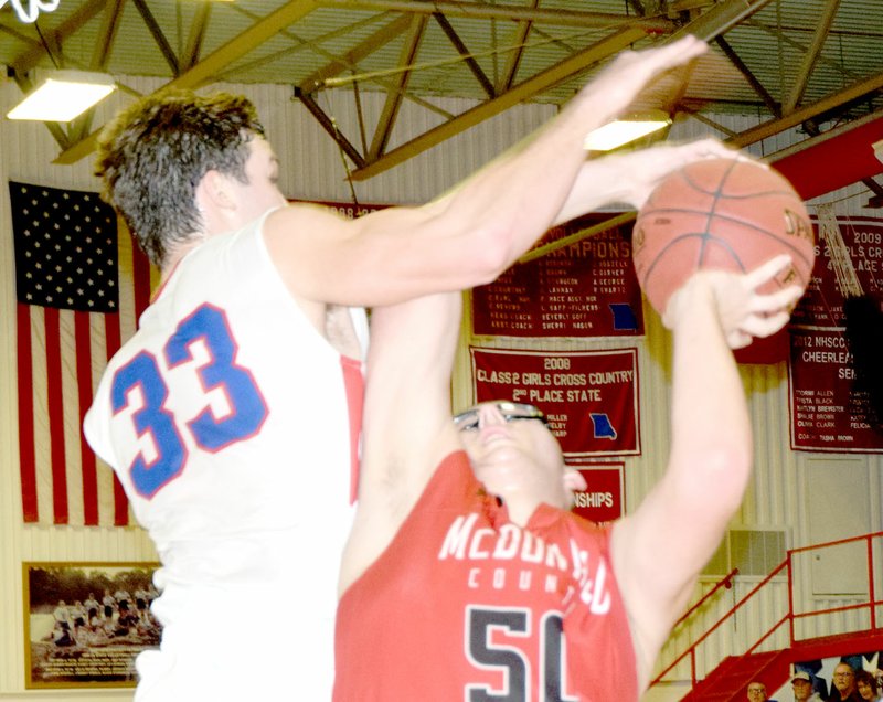 RICK PECK/SPECIAL TO MCDONALD COUNTY PRESS McDonald County's Tim Shields gets fouled by East Newton's Dustin McDermott during the Mustangs' 60-45 win on Feb. 2 at East Newton High School. Shields finished with a career-high 25 points to lead McDonald County.