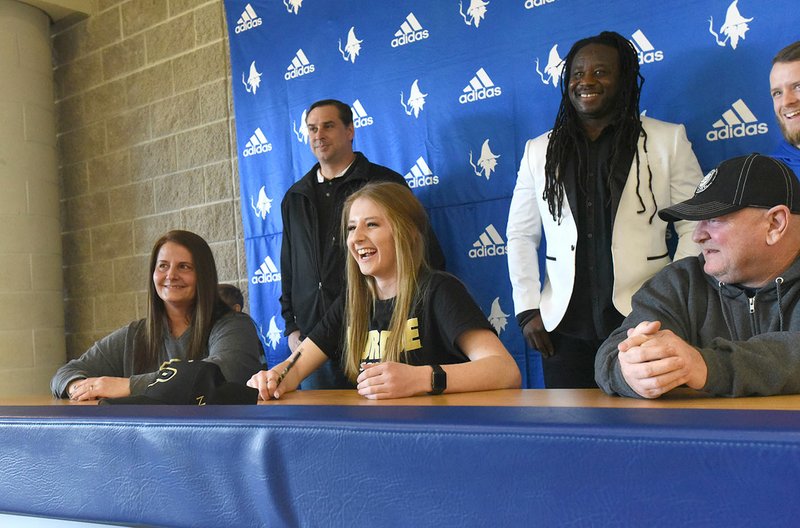 NWA Democrat-Gazette/FLIP PUTTHOFF Skylurr Patrick (center) laughs with classmates during her signing ceremony Wednesday at Rogers High School. Patrick will play soccer at Purdue.