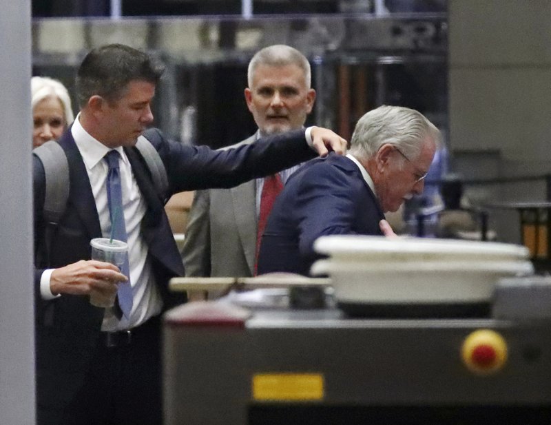 Former Uber CEO Travis Kalanick, left, adjusts the jacket of another man after passing through security at a federal courthouse on Wednesday, Feb. 7, 2018, in San Francisco.  (AP Photo/Ben Margot)