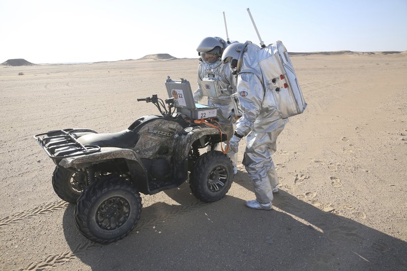 In this Feb. 7, 2018, photo, two scientists test space suits and a geo-radar for use in a future Mars mission in the Dhofar desert of southern Oman. The desolate desert in southern Oman resembles Mars so much that more than 200 scientists from 25 nations organized by the Austrian Space Forum are using it for the next four weeks to field-test technology for a manned mission to Mars. 