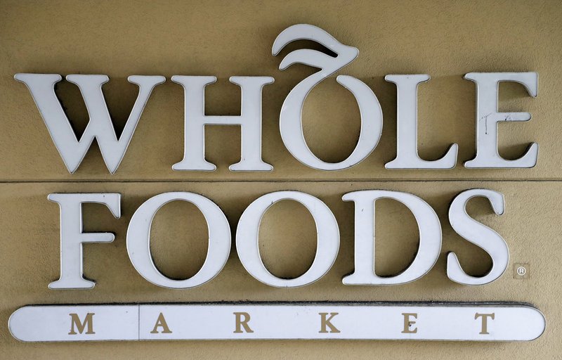 In this Aug. 28, 2017 file photo, a sign at a Whole Foods Market greets shoppers in Tampa, Fla. The online retailing giant plans to roll out two-hour delivery at the organic grocer this year to those who pay for Amazon's $99-a-year Prime membership. The move is the latest by Amazon to put its stamp on its recent purchase of Whole Foods.  