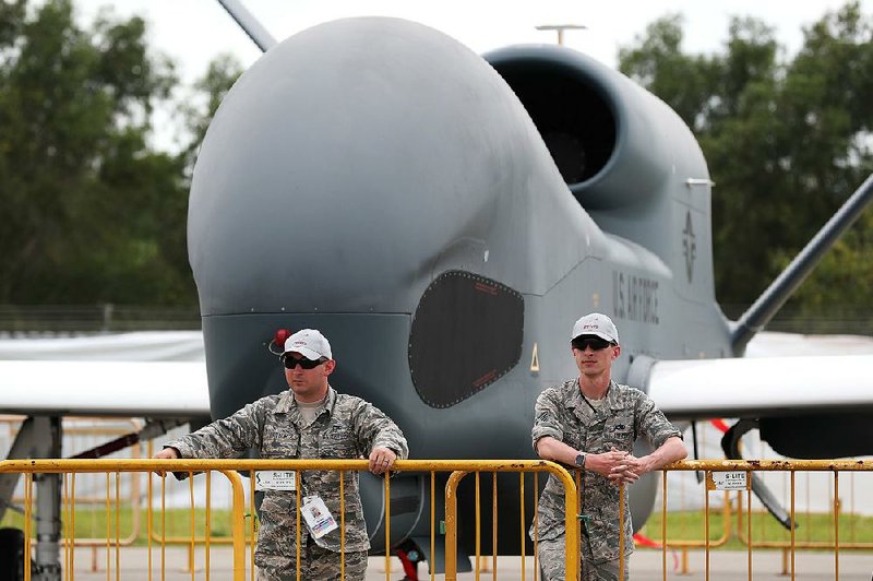 Members of the U.S. Air Force stand in front of a Northrop Grumman Global Hawk surveillance drone this week at the Singapore Airshow. The air show runs through Sunday. 