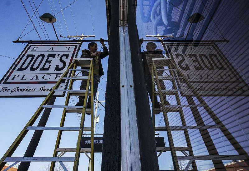 Arkansas Democrat-Gazette/MITCHELL PE MASILUN --2/8/2018--
Jeff McCourt with Sellers Electric works on lights at Doe's Eat Place in Little Rock Thursday, February 8, 2018. 