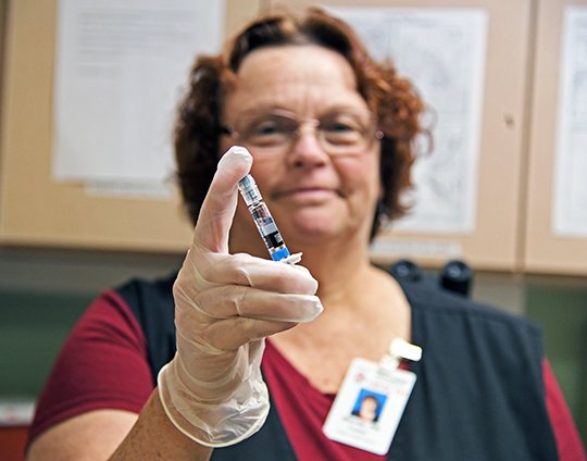 The Sentinel-Record/Grace Brown FLU VACCINE: Denise Focken, RN, displays a vial of the influenza vaccine at the Garland County Health Unit, 1425 Malvern Ave., on Thursday. The Arkansas Department of Health is offering free flu shots at all Local Health Units in the state. The Garland County Health Unit is open from 8 a.m. to 4:30 p.m.