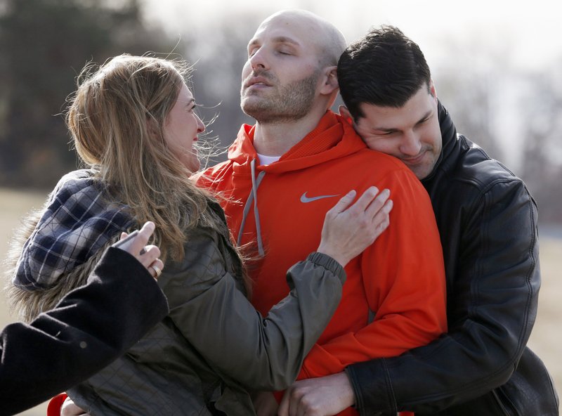  In this March 14, 2014, file photo, Michael Behenna, center, is embraced by his brother Brett and girlfriend Shannon Wahl following his release from prison in Leavenworth, Kan. Behenna, who was convicted of killing an Iraqi prisoner, served five years of his 15-year sentence for unpremeditated murder in a combat zone. Oklahoma's Attorney General Mike Hunter is urging President Donald Trump to issue a pardon to Behenna. 
