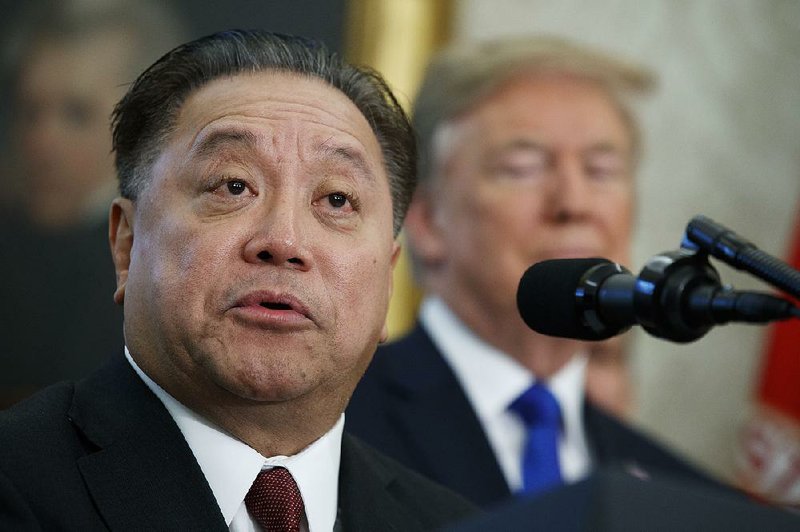 In this Thursday, Nov. 2, 2017, file photo, Broadcom CEO Hock Tan speaks as President Donald Trump listens during an event to announce the company is moving its global headquarters to the United States, in the Oval Office of the White House, in Washington. Broadcom is making an unsolicited, $130 billion offer for rival chipmaker Qualcomm. 