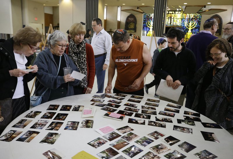 People look at a display of photos during a final service held at United Orthodox Synagogues in Houston as part of a farewell event. The building was damaged by three recent fl oods that occurred on Memorial Day 2015, on Tax Day 2016, and the fl oods caused by Hurricane Harvey in August last year.