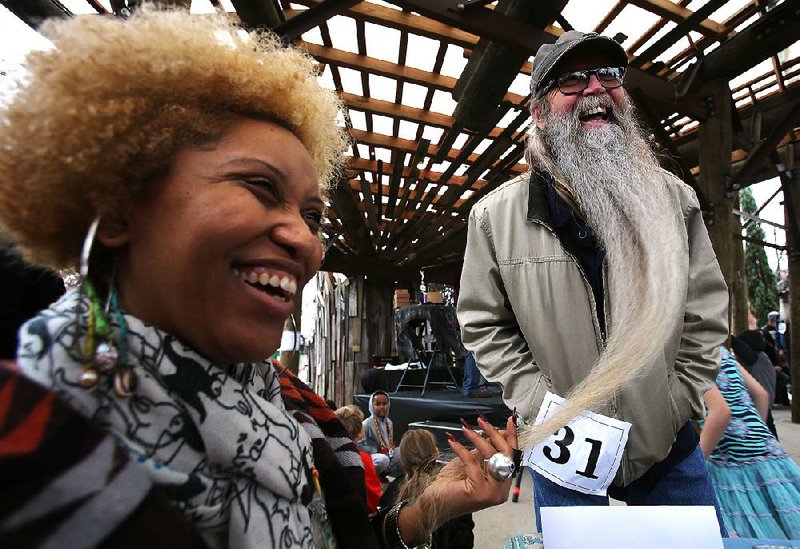 Judge Crystal C. Mercer (left) checks out contestant Alan Sears’ beard Saturday during the sixth annual Beard and Mustache Contest at The Bernice Garden in Little Rock. Sears won an honorable mention in the Best Beard Over Six Inches category.