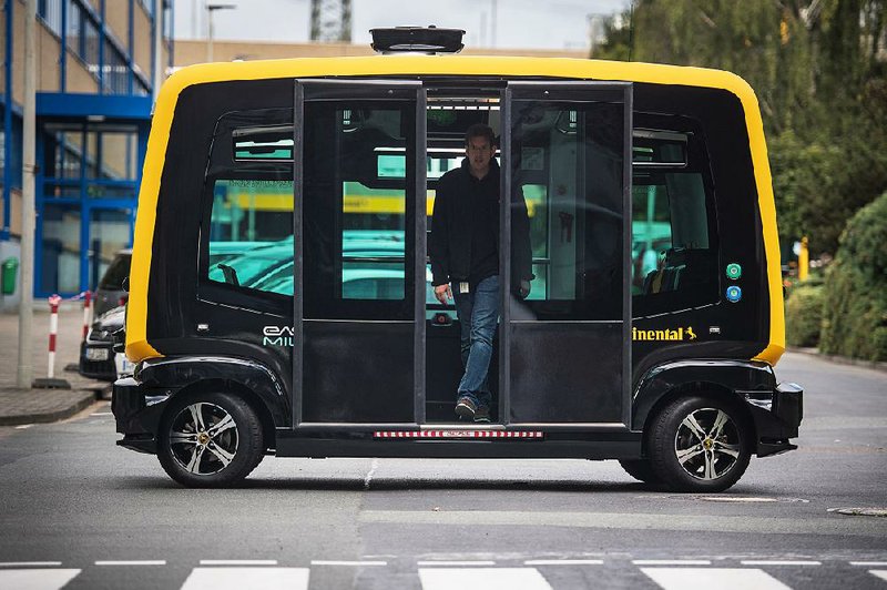 A rider emerges from from a Cube self-driving taxi last September in Frankfurt, Germany.