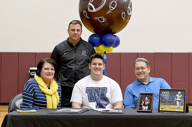 Bud Sullins/Special to Siloam Sunday Siloam Springs senior Isaac Knudsen signed Wednesday to play football at William Penn University in Oskaloosa, Iowa. Pictured are: Front from left, mother Sena Knudsen, Isaac Knudsen, father Bruce Knudsen and former Siloam Springs head football coach Bryan Ross, back.