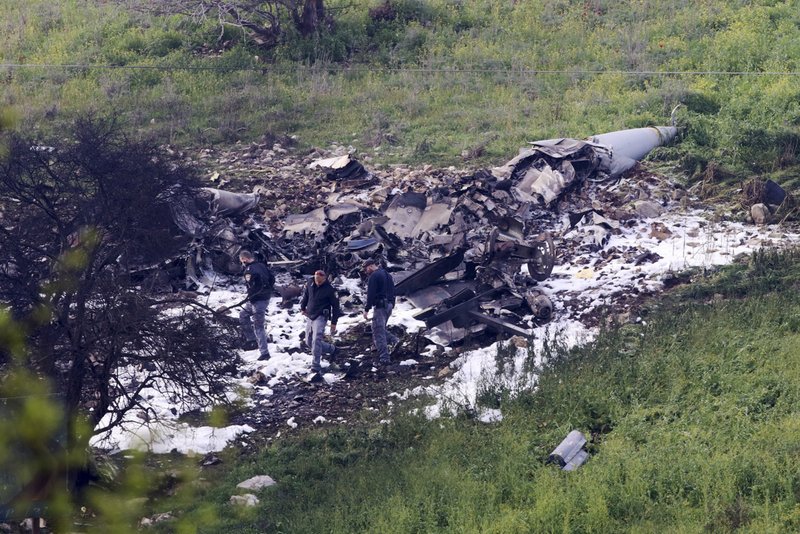 Israeli security stands around the wreckage of an F-16 that crashed in northern Israel, near kibbutz of Harduf, Saturday, Feb. 10, 2018. The Israeli military shot down an Iranian drone it said infiltrated the country early Saturday before launching a &quot;large-scale attack&quot; on at least a dozen Iranian and Syrian targets inside Syria, in its most significant engagement since the fighting in neighboring Syria began in 2011. Responding anti-aircraft fire led to the downing of an Israeli fighter plane. (AP Photo/Rami Slush) ***ISRAEL OUT***