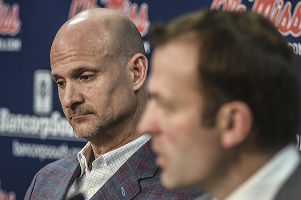 Mississippi head coach Andy Kennedy, left, listens as athletic director Ross Bjork speaks at a press conference at the Pavilion at Ole Miss in Oxford, Miss. on Monday, February 12, 2018. Kennedy, in his 12th season as Mississippi head coach, announced he would not return as coach following this season. (Bruce Newman, Oxford Eagle via AP)
