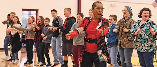 The Sentinel-Record/Grace Brown PERFORMANCE READY: Professional storyteller Linda Gorham dances with students in the Lake Hamilton Middle School gym during her performance about the Little Rock Nine on Monday.