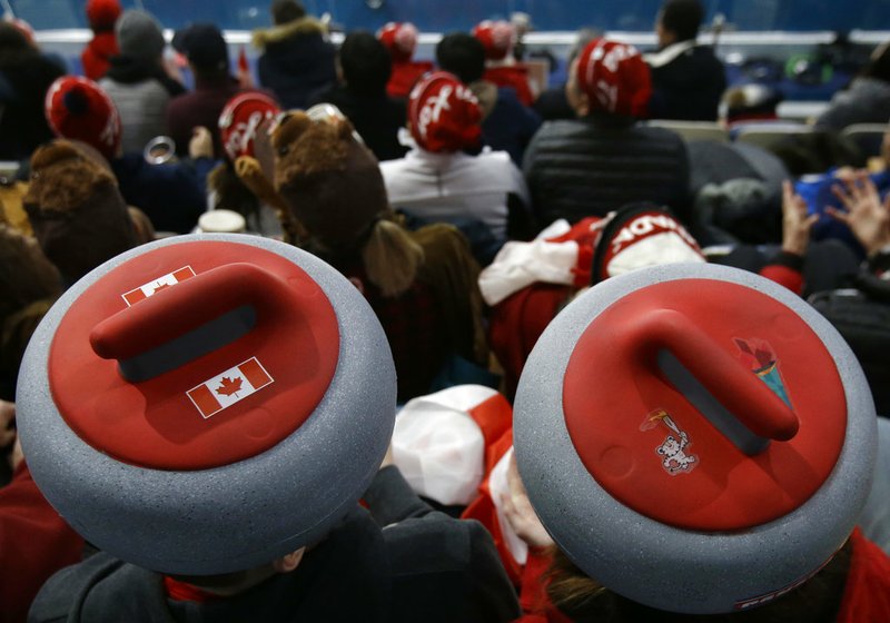 Spectators sport headwear shaped as curling stones as they watch the mixed doubles curling finals match against Canada and Switzerland at the 2018 Winter Olympics in Gangneung, South Korea, Tuesday, Feb. 13, 2018.