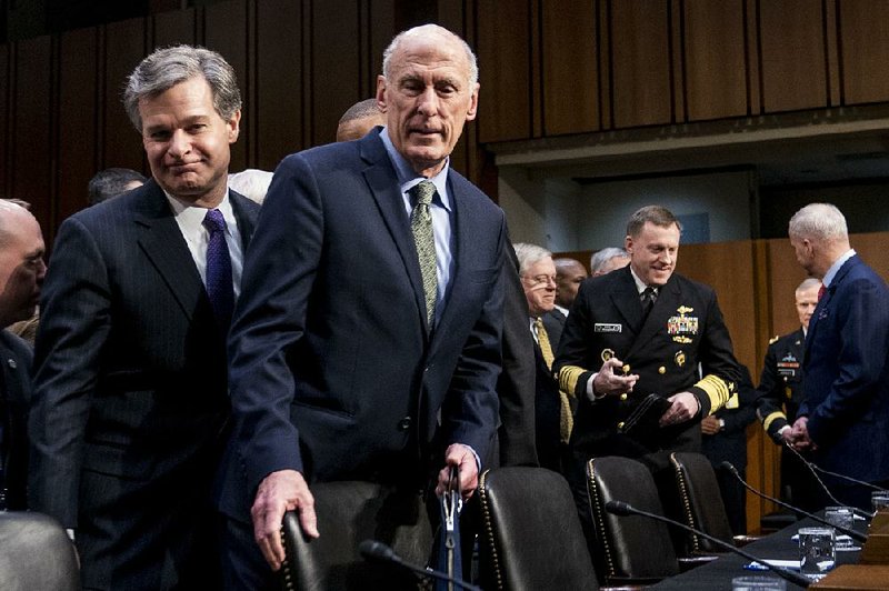 FBI Director Christopher Wray (left) and Director of National Intelligence Dan Coats arrive Tuesday to testify before the Senate Intelligence Committee. Wray said the FBI is undertaking “a lot of specific activities” to counter Russian meddling but was “not specifically directed by the president.”  