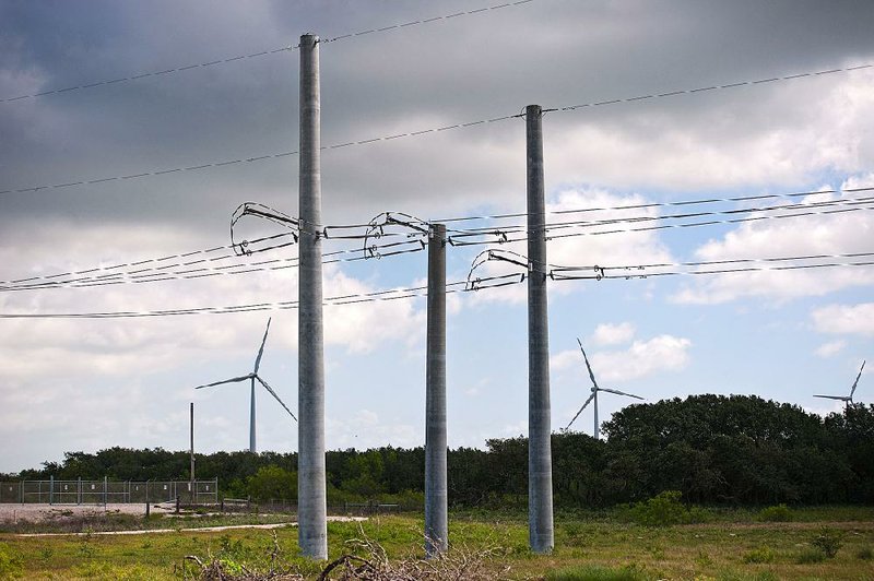 Transmission lines stand near a wind power project in Texas. A transmission line project across Missouri is proving the complexity of linking wind-generated power to areas of demand. 