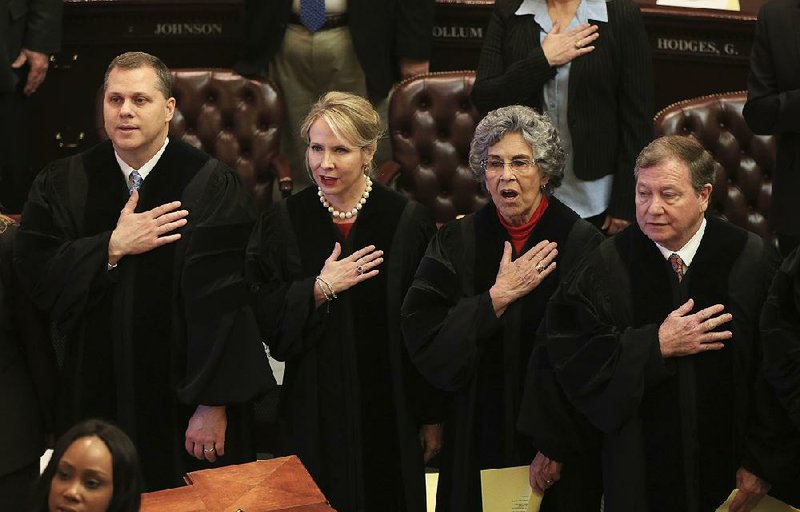 FILE - Arkansas Supreme Court Justices (left to right) Shawn A. Womack, Courtney Hudson Goodson, Josephine L. Hart and Robin F. Wynne recite the Pledge of Allegiance on Feb. 12, 2018 before Gov. Asa Hutchinson’s State of the State speech in the House chamber at the state Capitol.
