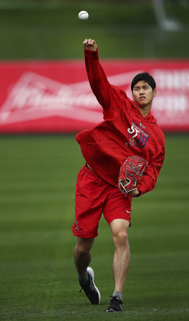 Shohei Ohtani of the Los Angeles Angels throws during a spring training workout Tuesday in Tempe, Ariz. The 23-year-old Japanese standout, who signed with the Angels two months ago, is getting looks both as a pitcher and as an outfielder. 