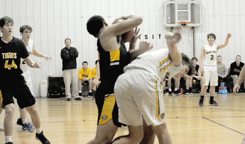 MARK HUMPHREY ENTERPRISE-LEADER Prairie Grove senior Demarkus Cooper rips the basketball out of the hands of a Haas Hall player during the Tigers' 73-49 regular season finale win Thursday at Fayetteville. Cooper's strength and mobility proved a valuable asset in a physical contest.