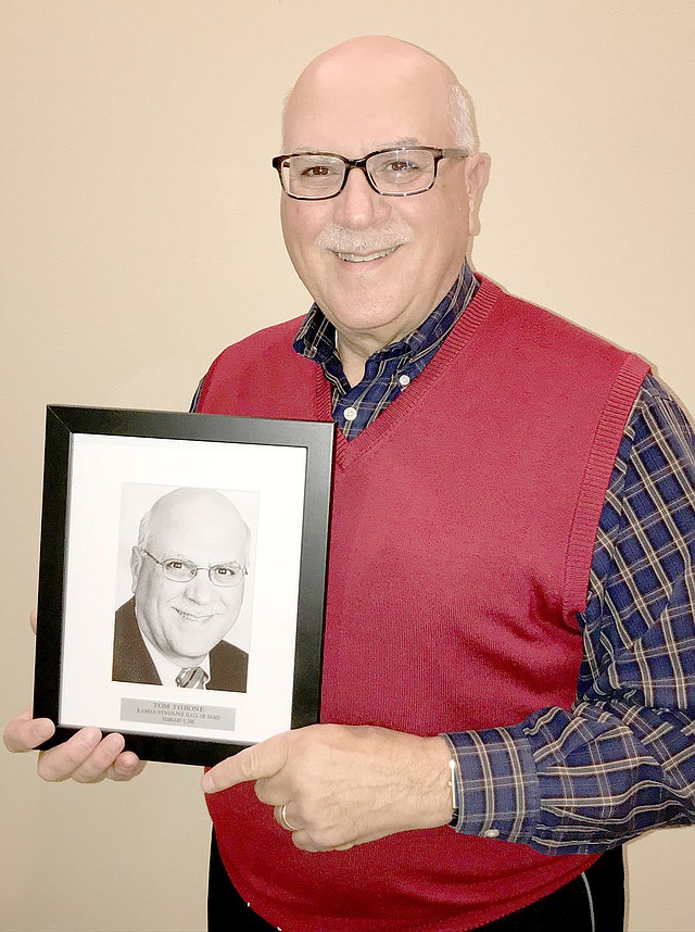 Photo courtesy of Tom Throne Tom Throne stands with a plaque commemorating his induction in to the Kansas Newspaper Hall of Fame.