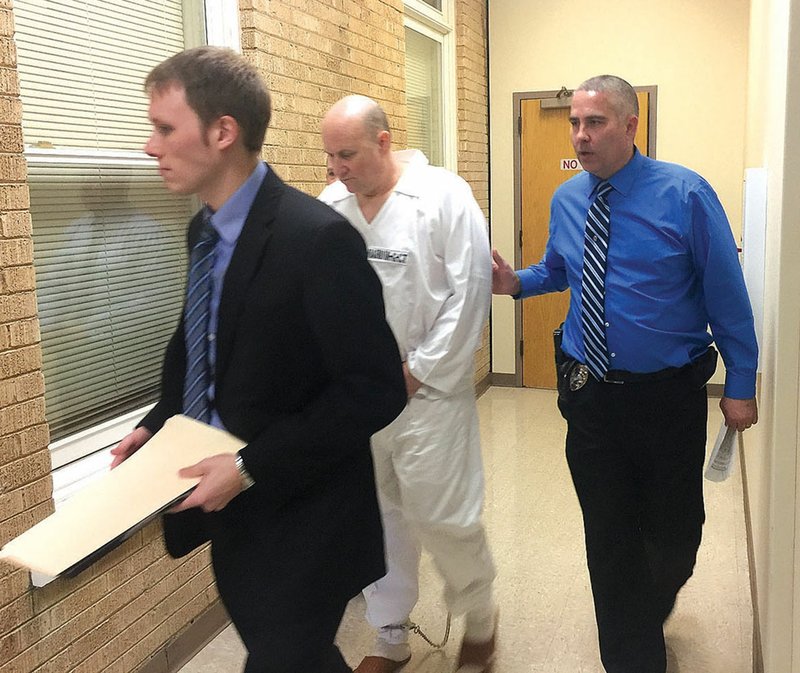 TRACY M. NEAL
 Kevin Lammers, a Benton County deputy public defender, walks in front of Grant Hardin who is being escorted into court by Larry Taylor, a Rogers police detective. Hardin was arrested Monday in connection with the 1997 rape of a Rogers school teacher.