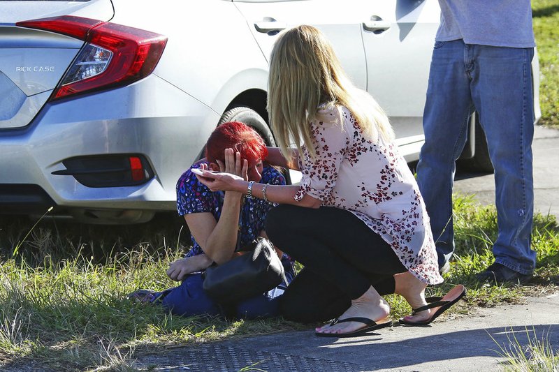 A woman consoles another as parents wait for news regarding a shooting at Marjory Stoneman Douglas High School in Parkland, Fla., on Wednesday, Feb. 14, 2018. 