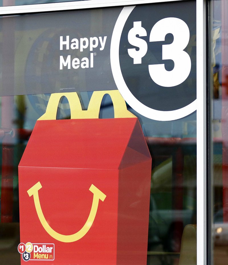 A $3 Happy Meal is advertised at a McDonald's restaurant in Brandon, Miss., Wednesday, Feb. 14, 2018. McDonald’s will soon banish cheeseburgers and chocolate milk from its Happy Meal menu in an effort to cut down on the calories, sodium, saturated fat and sugar that kids consume at its restaurants. Diners can still ask specifically for cheeseburgers or chocolate milk with the kid’s meal, but the fast-food company said that not listing them will reduce how often they’re ordered. 