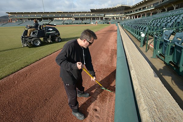 Sporty Rodriguez, a maintenance worker with the University of Arkansas' athletics department, uses a fan rake to dress the warning track Thursday, Feb. 15, 2018, at Baum Stadium in Fayetteville as he and others prepare for the baseball team's opening day. The Razorbacks host Bucknell at 3 p.m. today in the first of a three-game series to open the season.
