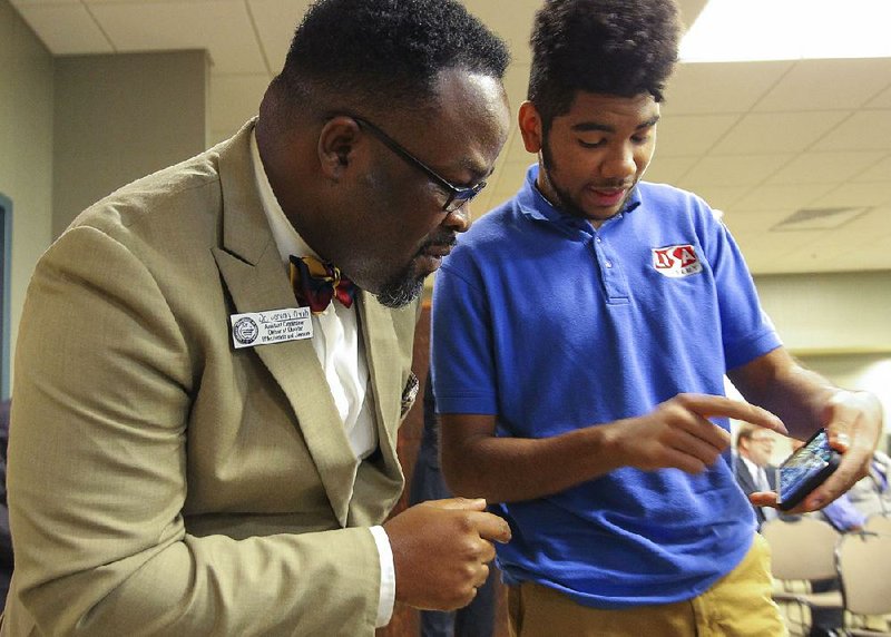 2018 FILE PHOTO: Jeremy Owoh (left), assistant commissioner at the state Department of Education’s Charter Authorizing Panel, gets an explanation from LISA Academy North student Jalen Sereal about a solar-car project that he and fellow students are building. 