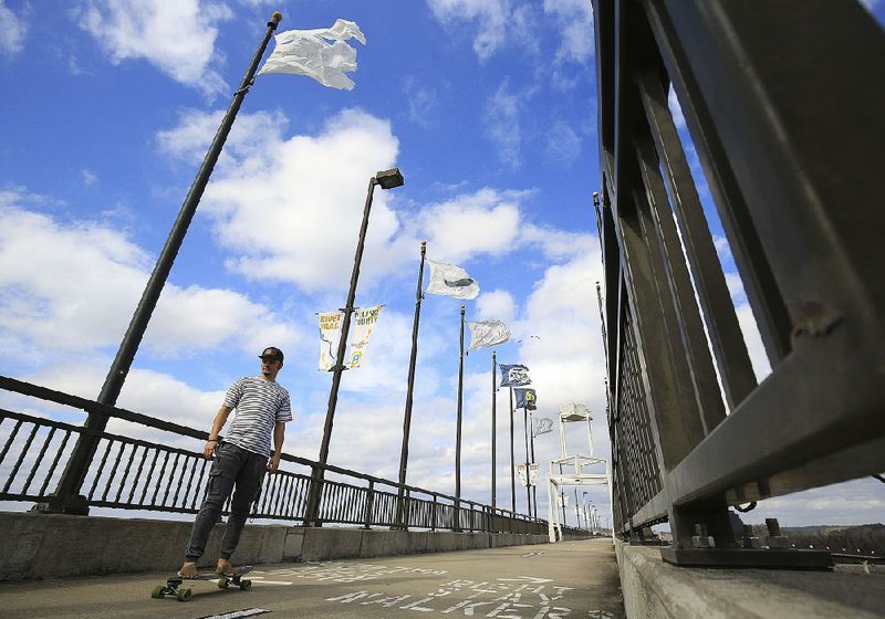 Arkansas Democrat-Gazette/STATON BREIDENTHAL --2/15/18-- Steven Donovan rides his skateboard across the Big Dam Bridge Thursday as he enjoys warm weather and blue skies. 