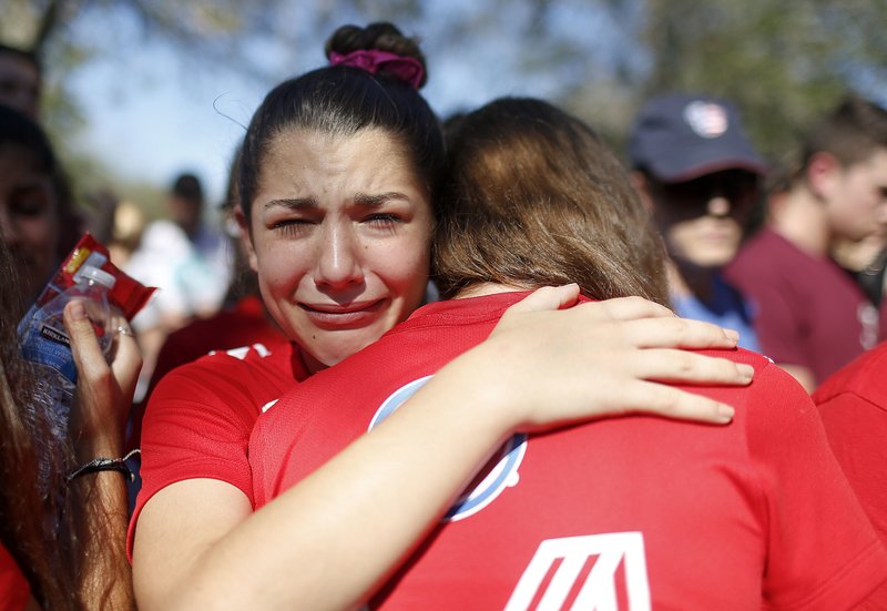 A student mourns the loss of her friend during a community vigil at Pine Trails Park, Thursday, Feb. 15, 2018, in Parkland, Fla., for the victims of the shooting at Marjory Stoneman Douglas High School. Nikolas Cruz, a former student, was charged with 17 counts of premeditated murder on Thursday. (AP Photo/Brynn Anderson)
