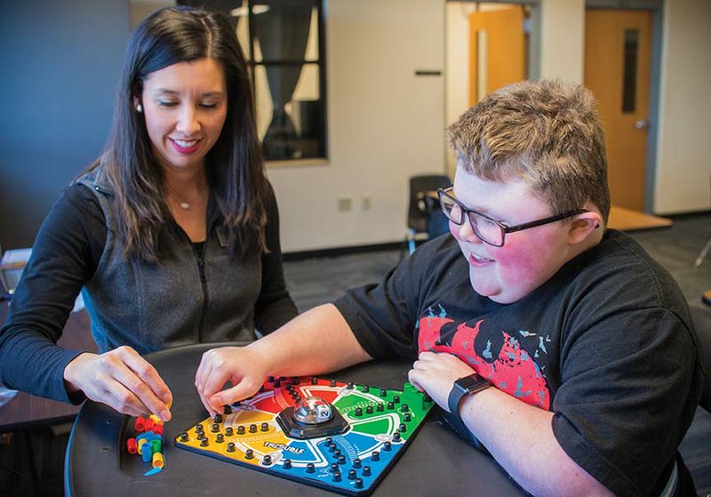 Brandon Pettit, 12, plays a game of Trouble with his occupational therapist, Cristina King. Pettit, who was diagnosed with Duchenne muscular dystrophy at a young age, is a seventh-grader at Bauxite Middle School. He enjoys studying science, playing video games and going to movies with his dad.