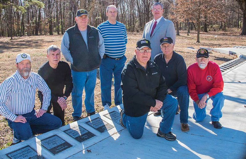 Posing with some of the tiles installed to date on the Walk of Honor under construction at the Veterans 
Memorial Park in Russellville are, front row, from left, Jim Bob Jackson, Bill Eaton and Bill Hefley; and back row, Ken Harper, president of the River Valley Veterans Coalition; Steve Hughes; Russ Hall; Richard Thomas; and Russellville Mayor Randy Horton. “There will be a few surprises in the Walk of Honor whenever we get the tiles all installed,” Harper said. The third phase of the park is expected to be underway in March.