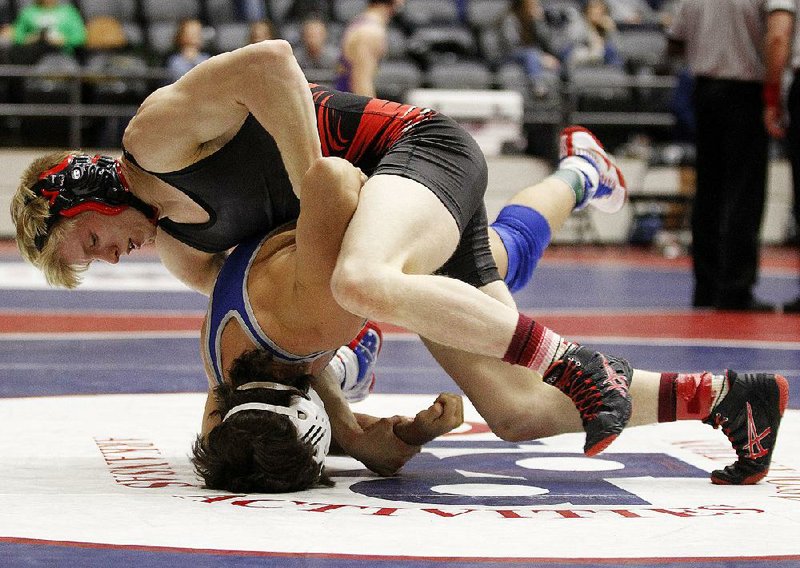 Russellville’s Logan Sloss takes down Bryant’s Dax Clatworthy during a quarterfinal match Friday in the high school state wrestling tournament at the Jack Stephens Center in Little Rock. Sloss, the No. 1 seed in the 145-pound weight class in Class 6A-7A, is attempting to win his second state title after winning the 138-pound championship as a sophomore. 