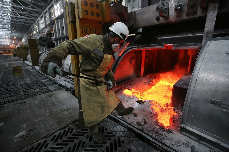 A worker manipulates molten aluminum at a smelter in Krasnoyarsk, Russia. Russia would be among the countries affected by Commerce Department recommendations to impose tariffs and set quotas on aluminum and steel imports.