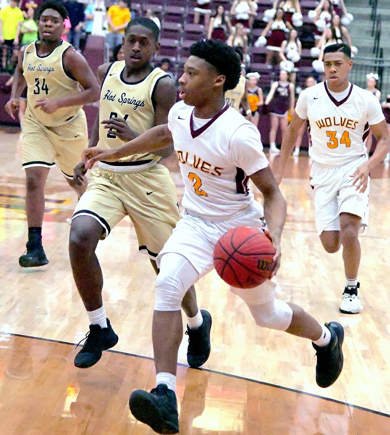 The Sentinel-Record/Grace Brown IN CONTROL: Lake Hamilton's Mondo Watkins (2) drives past Hot Springs' Curtis Frierson at Wolf Arena Thursday. The Wolves took a 60-47 win over the Trojans as the teams wrapped up the regular season.