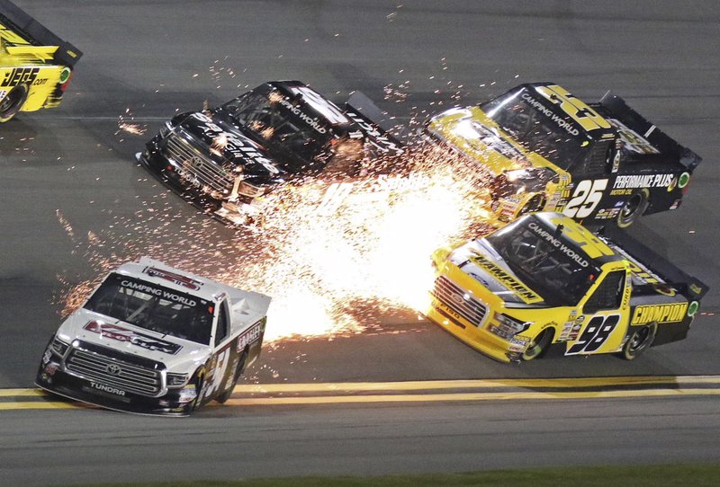 Sparks fly from the truck of driver Bo LeMastus (54) as Grant Enfinger (98), Noah Gragson (18) and Dalton Sargeant (25) try to drive past during the NASCAR Truck Series auto race at Daytona International Speedway in Daytona Beach, Fla., Friday, Feb. 16, 2018. (AP Photo/Darryl Graham)