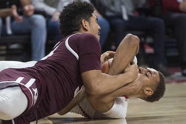Arkansas' Daniel Gafford (below) wrestles Texas A&M's Tyler Davis for possession during a game Saturday, Feb. 17, 2018, in Fayetteville. 