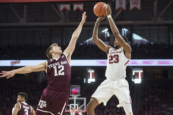 Arkansas guard C.J. Jones shoots over Texas A&M defender Chris Collins during a game Saturday, Feb. 17, 2018, in Fayetteville. 

