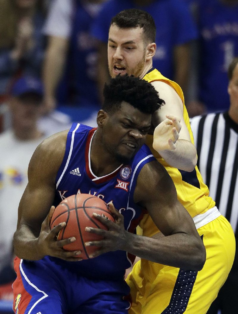 Kansas center Udoka Azubuike (front) drives to the basket against West Virginia’s Maciej Bender during Saturday’s game in Lawrence, Kan. Azubuike led the Jayhawks with 21 points. 