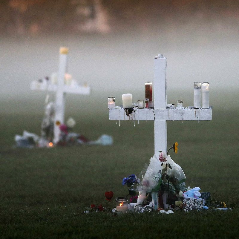 Morning fog on Saturday enshrouds 17 memorial crosses for the victims of the shooting Wednesday at Marjory Stoneman Douglas High School in Parkland, Fla.