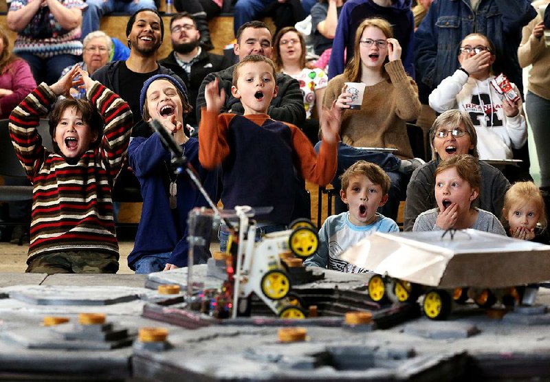 Spectators react as robots from the Levy the Falcon Dog and The Aristocrats teams collide Saturday during a first-round match in the annual bot battle competition at the Arkansas Regional Innovation Hub in North Little Rock. 