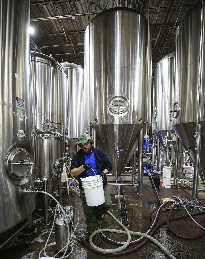 Jerry Gorman cleans fermenting tanks Wednesday at Lost Forty Brewing, where two new 90-barrel fermenters will help produce more specialty beers. 