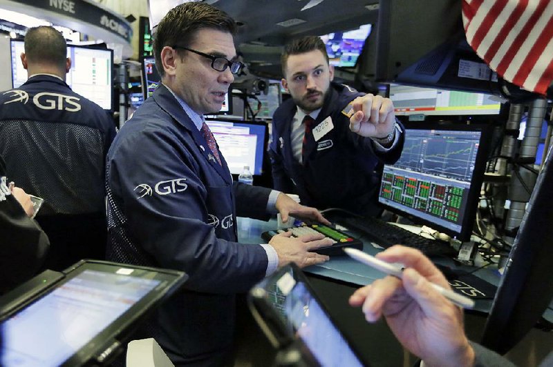 Robert Tuccillo (center) and Matthew Greiner work last week on the floor of the New York Stock Exchange. 