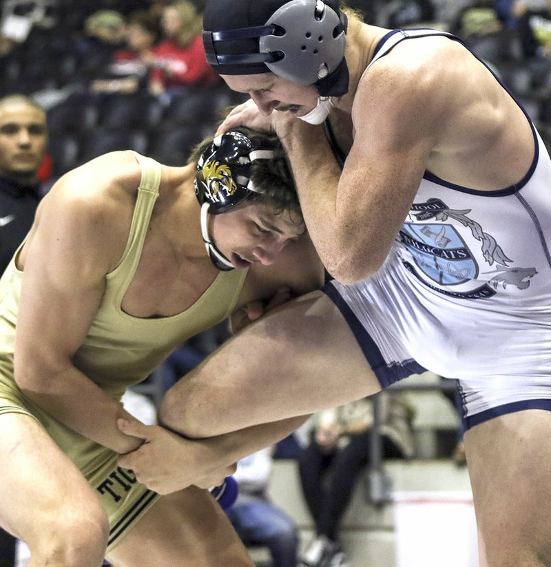 Bentonville High’s Cash Jones (left) hooks the leg of Springdale Har-Ber’s Britton Bowman on Saturday during the Class 6A-7A 170-pound championship match at the Jack Stephens Center at the University of Arkansas at Little Rock.
