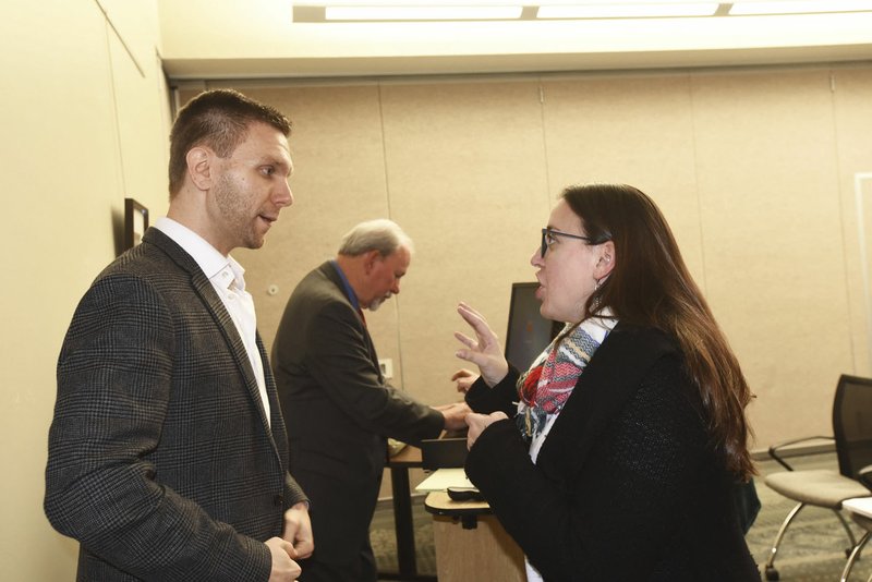 NWA Democrat-Gazette/FLIP PUTTHOFF Evin Demirel (left) and Lisa Corrigan, two of the speakers at the Race in Arkansas program, chat Saturday during a break at Northwest Arkansas Community College in Bentonville. Moderator Jon Comstock, a former Benton County Circuit Judge, is at center.