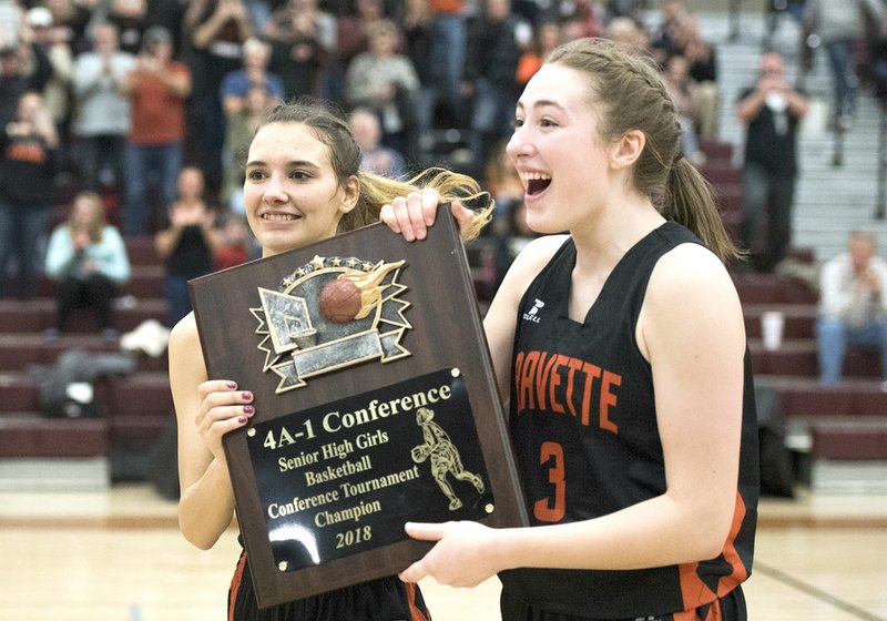 NWA Democrat-Gazette/CHARLIE KAIJO Gravette's Tori Foster (22) and Kyrstin Branscum (3) collect the 4A-1 Conference championship plaque Saturday after defeating Berryville at Lincoln High School in Lincoln.