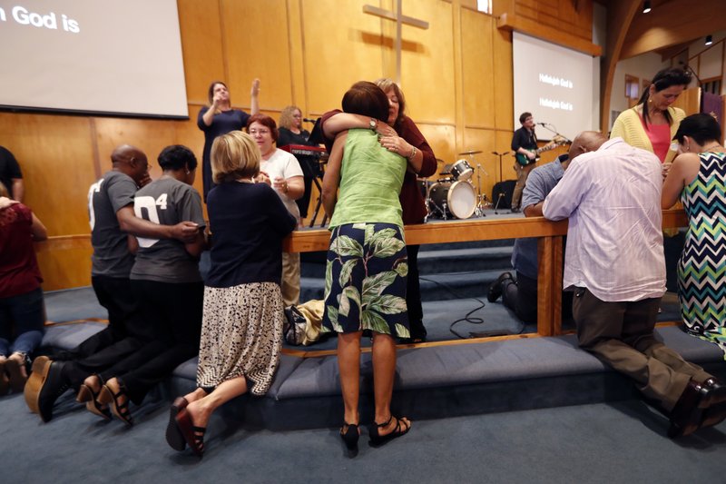 Congregation members kneel at the alter during a service at the First United Methodist Church in Coral Springs, Fla., on Sunday, Feb. 18, 2018. The service was dedicated to the victims of Wednesday's mass shooting at nearby Marjory Stoneman Douglas High School in Parkland. Nikolas Cruz, a former student was charged with 17 counts of murder. (AP Photo/Gerald Herbert)