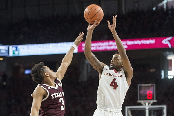 Daryl Macon of Arkansas makes a basket as Admon Gilder of Texas A&M guards in the second half Saturday, Feb. 17, 2018, during the game at Bud Walton Arena in Fayetteville.