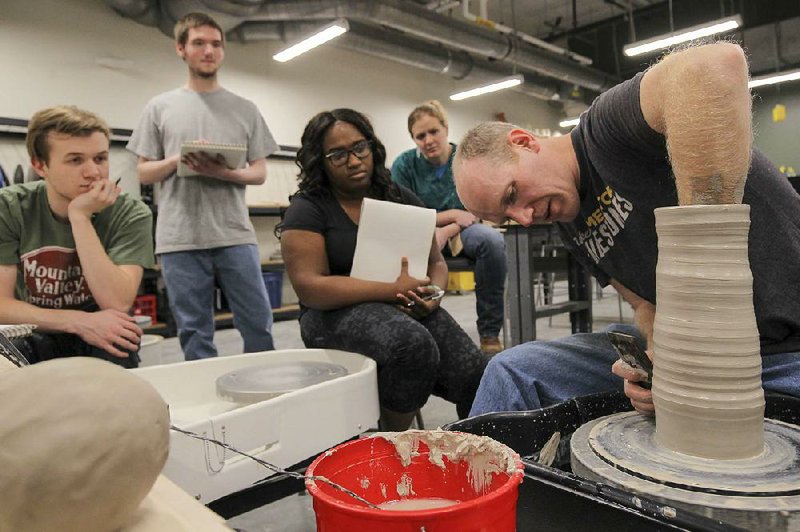 Visiting professor Fletcher Larkin demonstrates wheel throwing techniques to students in a ceramics class at the University of Arkansas at Little Rock’s new Windgate Center for Art + Design.